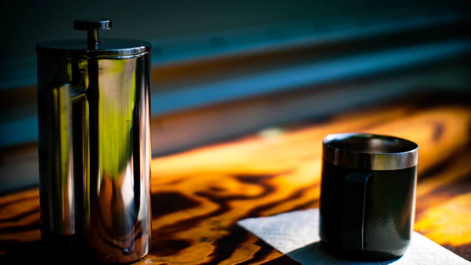 French press and a coffee mug resting in warm morning light